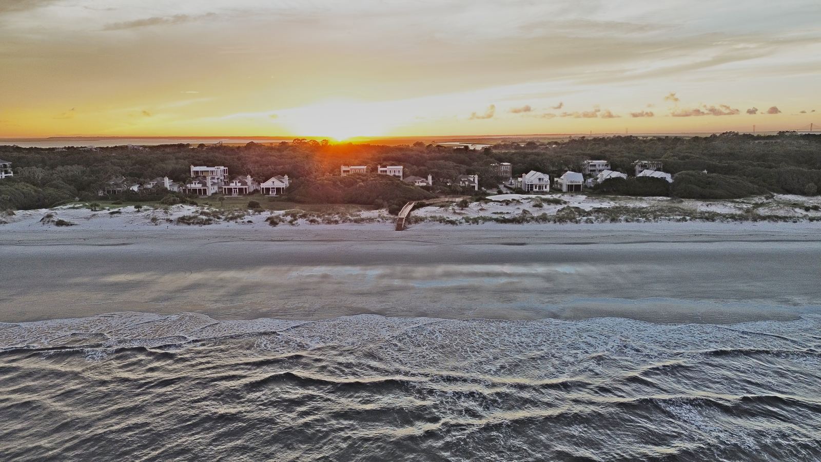 Aerial view at sunset of the Seaside Retreat geothermal residential development on Jekyll Island, Georgia, with homes set among the dunes along the Atlantic coastline
